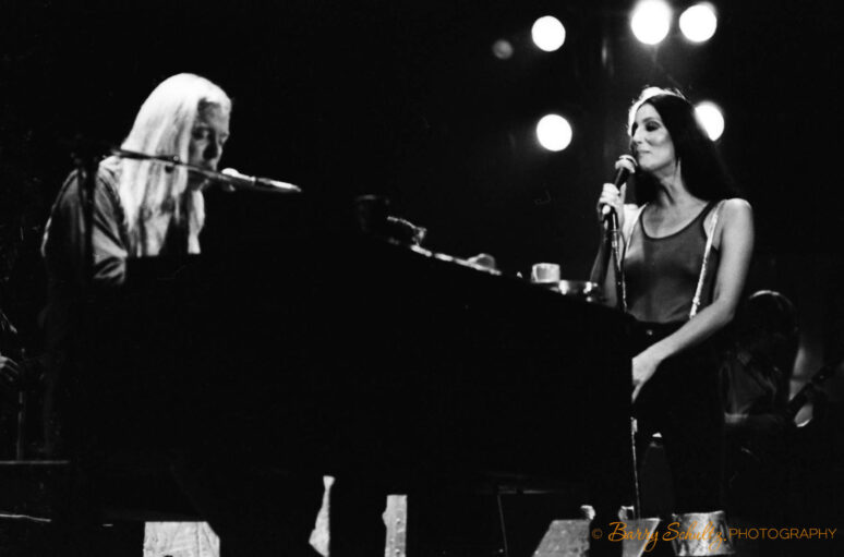 Black and white photograph of Cher performing live on stage during the 1970s.